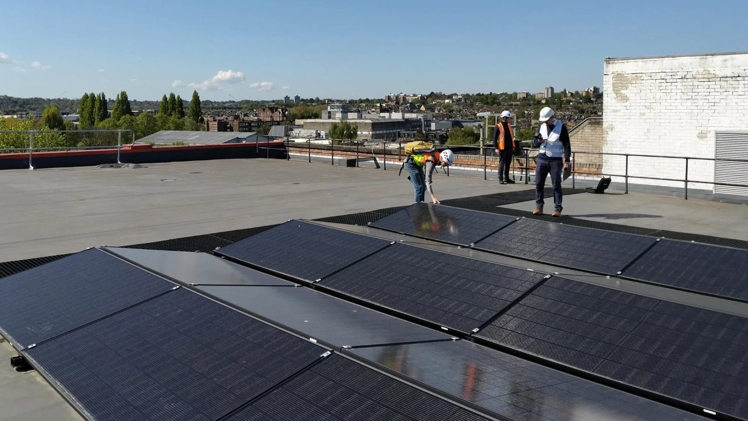 Installers fitting rooftop solar panels on a Shurgard self-storage building in Belgium